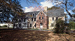 "rooms with green upholstery tended to be more important than those with blue." Since green was associated with "Venus, felicity and pleasure...it was often chosen for best beds." Fig. 2: Spencer-Peirce-Little Farm, Newbury (Historic New England) Colonel Daniel Peirce built this unusual grand stone manor house in about 1690 (the two-story brick entry porch dates to the 1790s). The cruciform plan provides two rooms flanking a center chimney, with a service ell on the back. A National Historic Landmark, it is one of the best preserved examples of its type; the most closely related surviving structure is Bacons Castle (1665) in Surry, Virginia. Still a functioning farm, the fields have continuously produced commercial crops since John Spencer purchased its four hundred acres in 1635.