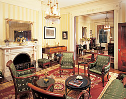 The double parlor pocket doors were removed to create one large room by a previous owner, but our couple reconstructed the original opening based on interior photos taken in 1904 (see next page) and had new pocket doors installed. The piano is labeled William Geib (New York) and the case may have been made in Duncan Phyfe's workshop or that of Deming & Bulkley. The carved mahogany oval table, 1819-1824, between the two rooms, is attributed to Isaac Vose and Son with Thomas Seymour, the preeminent cabinetmakers in Boston at the time. Chairs such as the four shown here, which have closed spaces between the arms and the seat are known as bergères. Two are reproductions of Harrison Gray Otis' office chair from the Otis House museum nearby that bears his name, and is the headquarters of Historic New England. The other pair is probably early nineteenth-century English in the French taste. Harrison Gray Otis (1765-1848), who made a fortune developing Beacon Hill, served as a representative in Congress and later became mayor of Boston.
