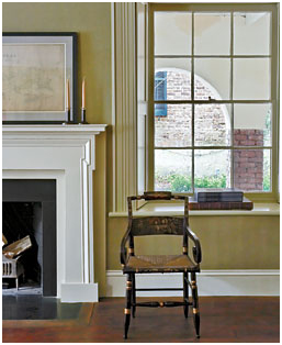 The arcaded lower-level piazza is visible through a window in the library on the ground floor. The mantel is one of the few new architectural elements, the original having been lost. Photography by Paul Costello; Image courtesy G.P. Schafer Architect.