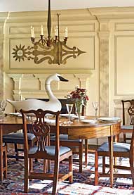 Set in silhouette against the paneled mantel is an extraordinary mid-nineteenth-century New England banner weathervane made of copper with yellow sizing and gilding, from Olde Hope Antiques. The swan decoy on the table was carved in the 1950s by Madison Mitchell (1901–1993), Havre de Grace, Maryland. The Benjamin Lincoln banquet table, 1790, probably Massachusetts, was originally owned by General Lincoln of Boston, the officer designated by General Washington to receive the British sword of surrender at the Battle of Yorktown in 1791. Six of the mahogany Chippendale chairs are from Nathan Liverant and Son, and originally came from the Brown residence in Adams, Massachusetts, circa 1800. The other six in the set were custom made to match by Robert Whitley Studios, Solebury, Pennsylvania. The Heriz carpet is early 1900s. The Pennsylvania chip-carved fireplace surround was reclaimed from a period interior; the pilasters were made for the space and marbleized by David Guilmet of Bell-Guilmet Associates. The chandelier is a reproduction from a pair Olde Hope purchased at the Egan sale (Northeast Auctions, 2006). Not shown in this room is a primitive fruit still life, artist unknown, and a Southern Hepplewhite sideboard, probably from Athens, Georgia, and purchased from Deanne Levison.