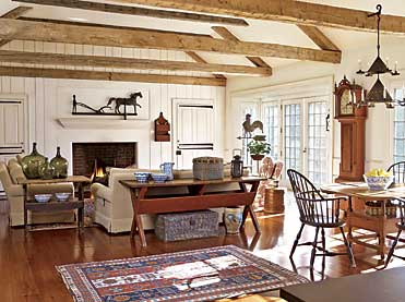 The mid-nineteenth-century weathervane with farmer, horse, and plow, is one of a kind. It was found in Cooper, Pennsylvania. Complementing the form are iron strap hinges on the door. The two-tiered red-painted hanging wall box is New England, 1820s­–1830s, and the rooster weathervane dates to the early twentieth century. The circa–1800 Riley Whiting tall clock, Winchester, Connecticut, was purchased from Deanne Levison and retains its red stain with figured wood inlay. A blue-painted box from New England is placed under the sawbuck table with original red paint. To the left is a circa–1840 bench table with original brown paint and scrubbed top, with spongeware bowls beneath and demijohn bottles above.