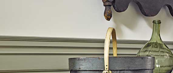 The blue-painted carrier and Pennsylvania dower chest from the previous image are shown with a cobalt-decorated New York stoneware churn stamped “Maker-M. Woodruff, Cortland.”