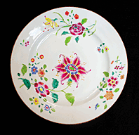 Fig. 11: Plate, Chinese export porcelain, Qing dynasty, Qianlong period (1736–1795). Part of a twelve-piece set originally associated with ownership by John Drayton in the mid-eighteenth century. Famille rose pattern. Overglazed polychrome floral designs with gilding. Flat plate with raised shoulder and cylindrical foot rim: Diam. 8-7/8 in.; foot rim diam. 4-7/8, H. 1 in. Donation of Anne Drayton Nelson. Courtesy, Drayton Hall, a historic site of the National Trust for Historic Preservation. Photography by Carter C. Hudgins.  