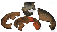 Fig. 13: A collection of reconstructed colonoware earthenware ceramic vessels recovered at Drayton Hall through archaeological excavations. The jug at the top is a traditional African form and has a rim diameter of 5 inches with an estimated height of 6 inches. The three bowls all have flat bottoms demonstrating a European influence. The vessel in the center is decorated with a “pie-crust rim” reminiscent of the rim treatment on English Staffordshire combed slipware vessels of the late seventeenth and eighteenth centuries. From left to right: Diam. 8-1/4, H. 1-1/2 in; Diam. 7-1/2, H. 2-1/4 in.; Diam. 9-1/4, H. 2-1/2 in. Courtesy, Drayton Hall, a historic site of the National Trust for Historic Preservation. Photography by Carter C. Hudgins.