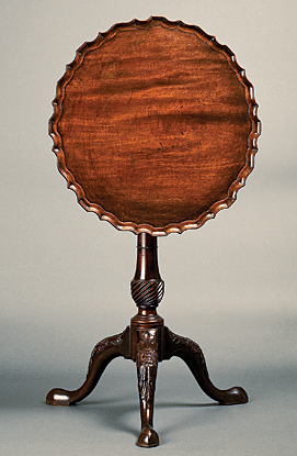 Kettle Stand, Charleston, S.C., ca. 1750–1760. Mahogany. H. 27-5/8, Diam. 21 in. Courtesy, the Rivers Collection, Charleston, S.C. Photograph provided by the Gibbes Museum of Art, where it is currently on view. The kettle stand is a rarity in American furniture. Used in conjunction with a larger tea table of similar design and decoration, the simple, bold pattern and heavy veining of this stand is in the Baroque style of such early carvers as Henry Burnett (American, d. 1761), the chief carver of St. Michael’s Church in downtown Charleston.